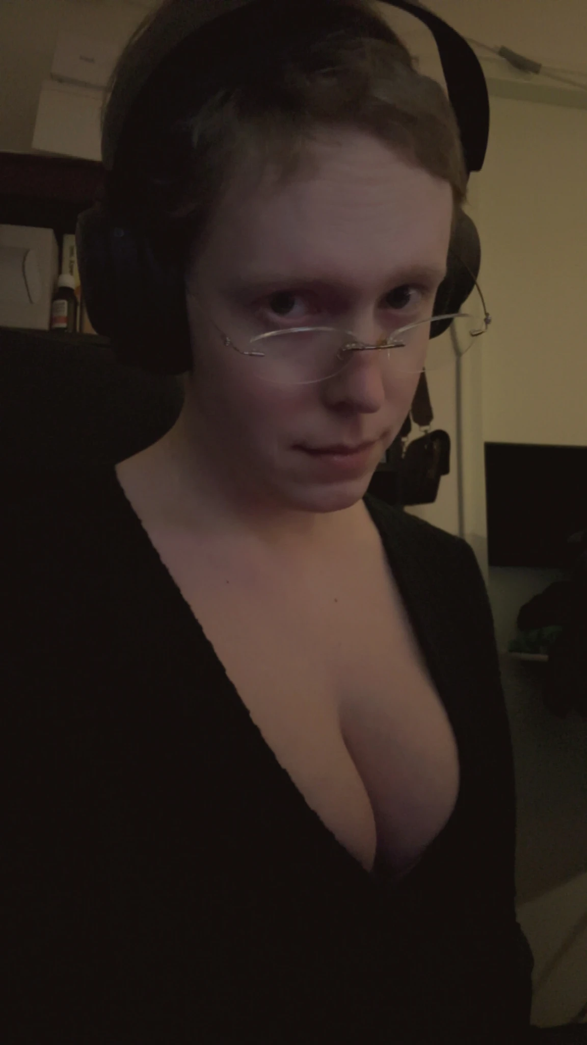 Slightly higher point of view from the previous, but now Siina is looking over her glasses at the camera, her eyebrows slightly raised.